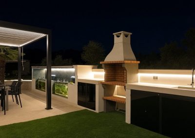 Barbacoa y cocina exterior iluminada de noche
